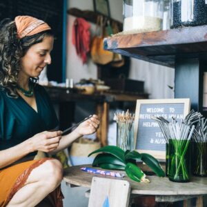 Woman in store with reusable straws and eco-friendly products promoting sustainability.
